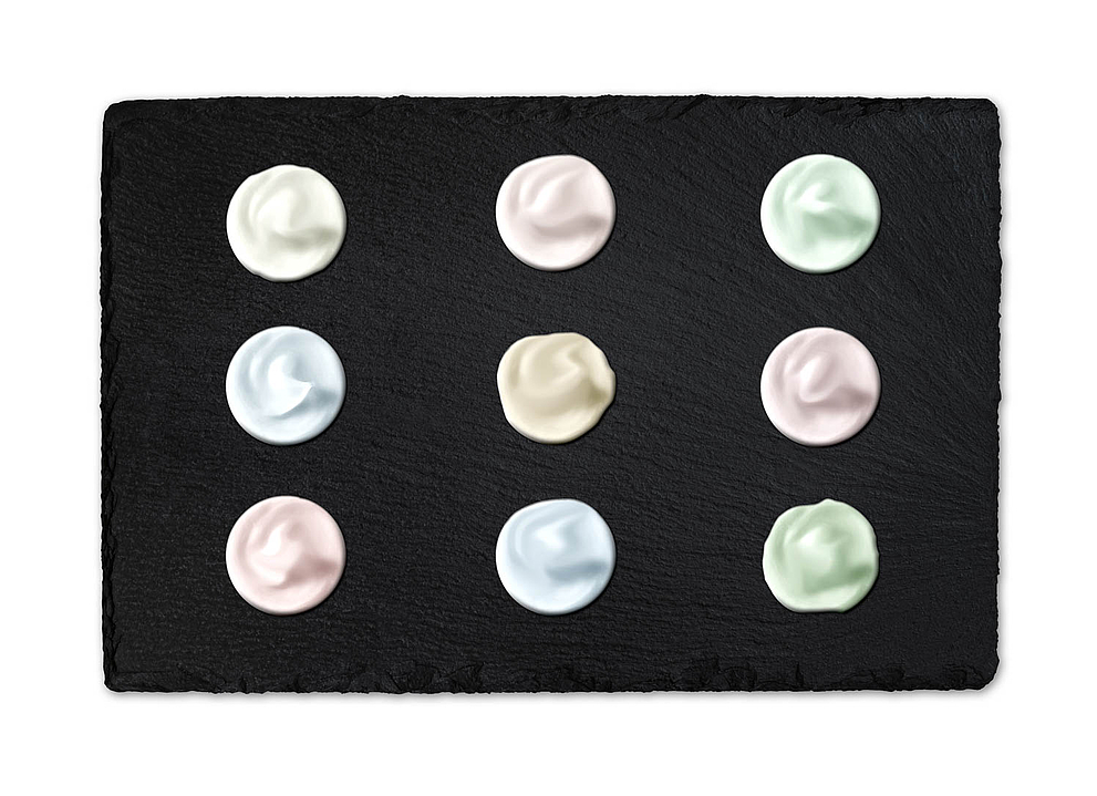 Slate serving board featuring nine pastel-colored dollops: white, pink, mint, light blue, beige, and other pastel shades arranged in a 3x3 grid.