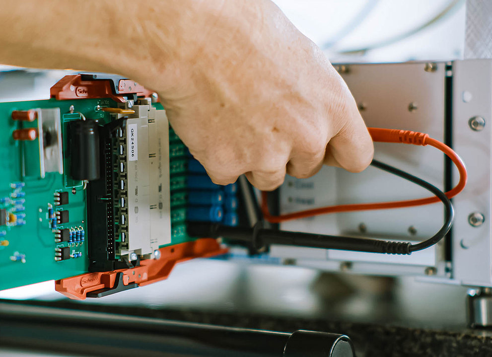Elektrisches Gerät. Eine Hand steckt Kabel ein