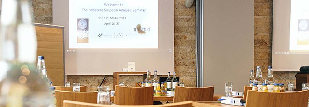 Seminarraum mit Holzmöbeln und Projektionsleinwand für Analyseveranstaltung